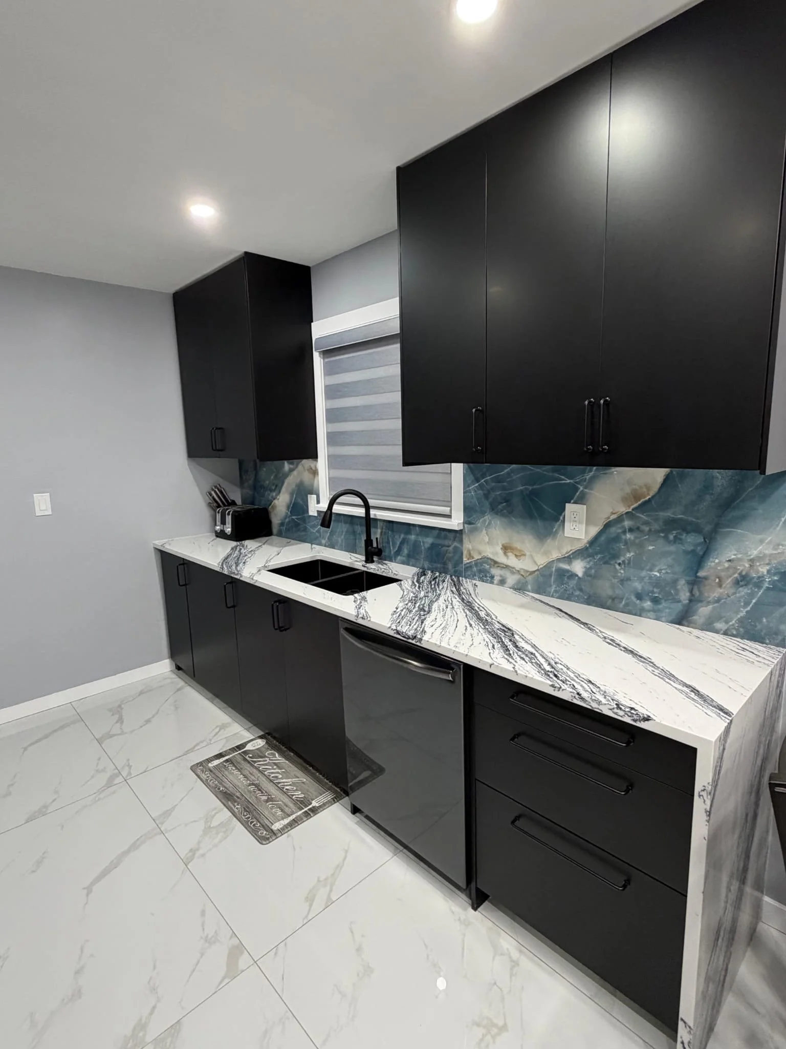 Kitchen renovation with black cabinets and marble countertops in St. Catharines