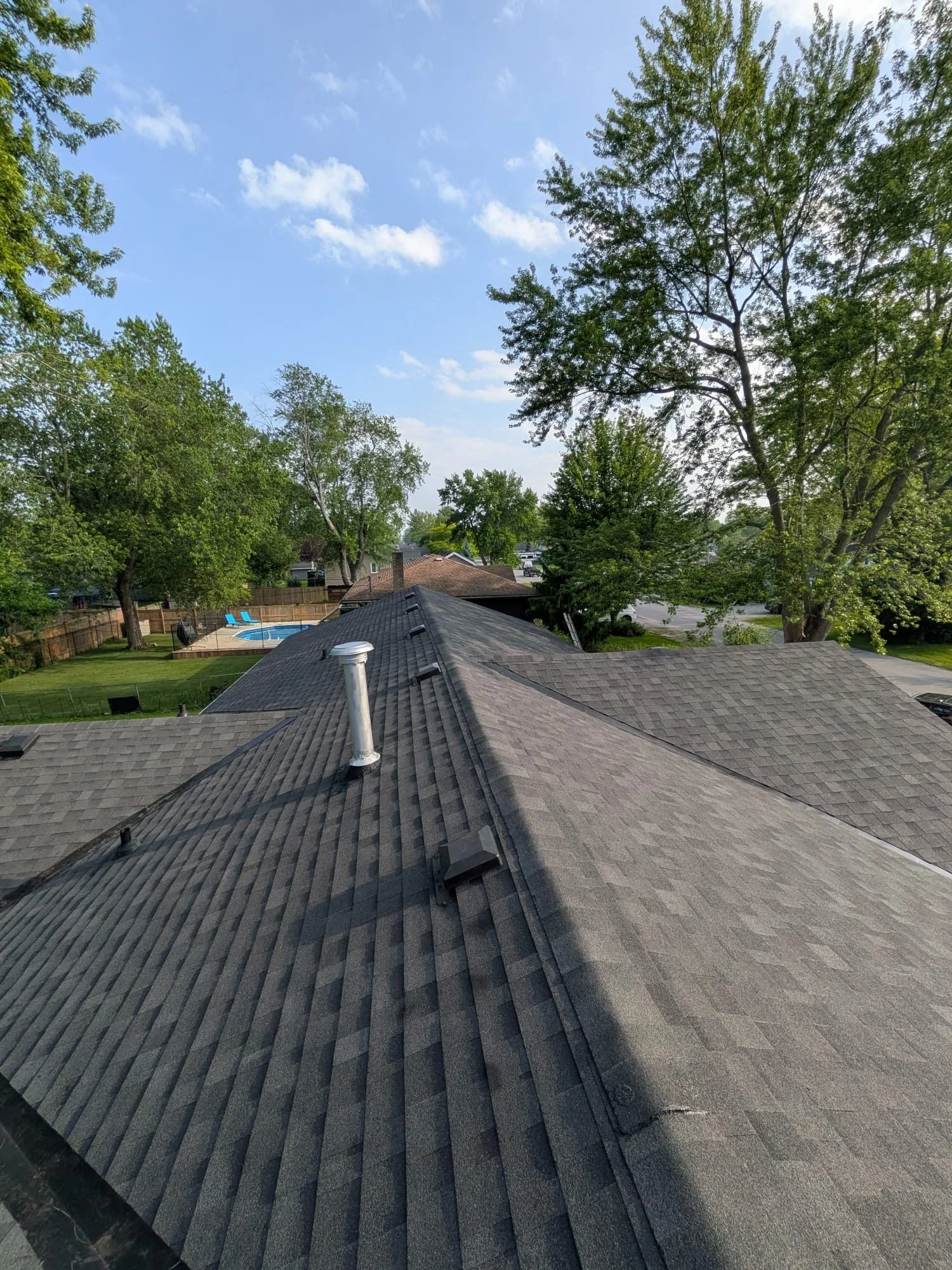 New asphalt shingle roof on a home with fenced backyard and pool in St. Catharines