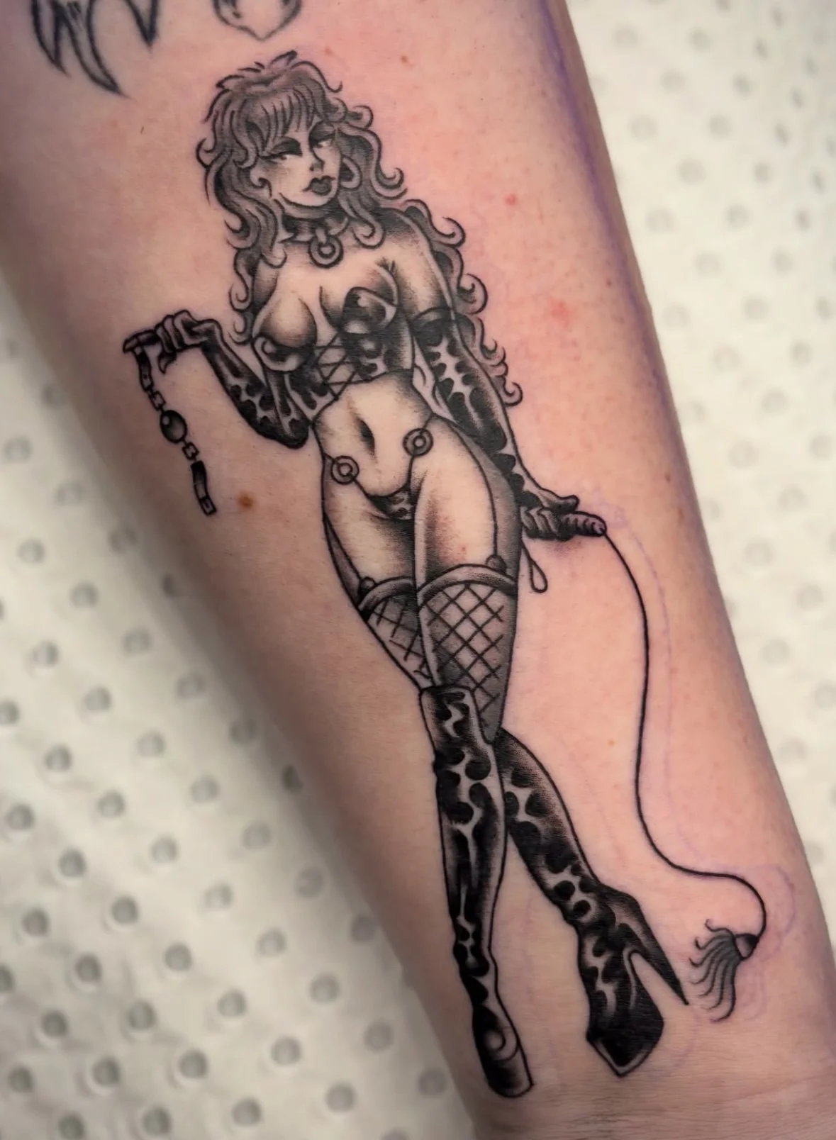 Black and grey Trad tattoo of a pinup dominatrix by Brandy G