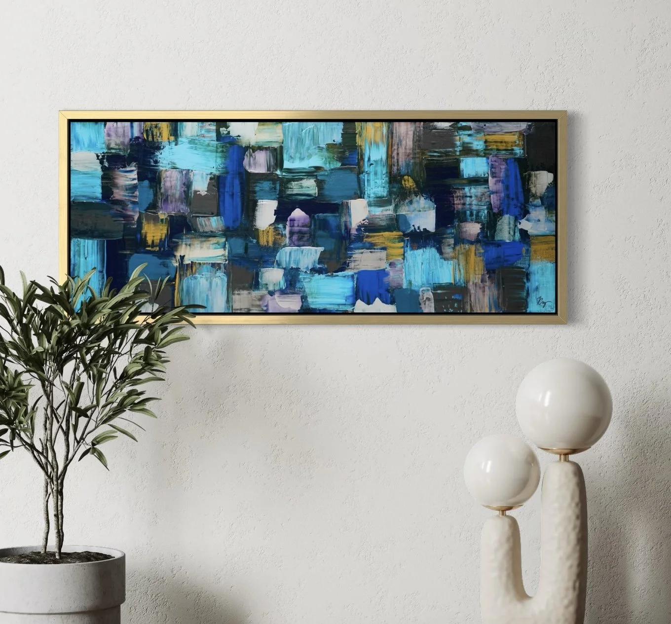 Interior with a large colorful abstract painting on a white wall, a potted plant on the left, and two decorative white ceramic sculptures with spherical tops on the right.