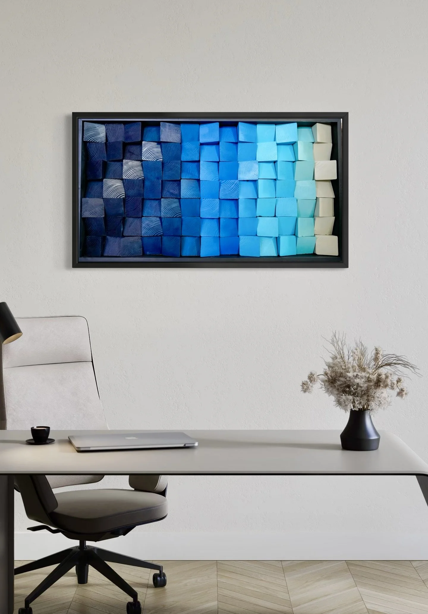 A framed artwork with a gradient of wooden blocks from dark blue to light blue and cream. 