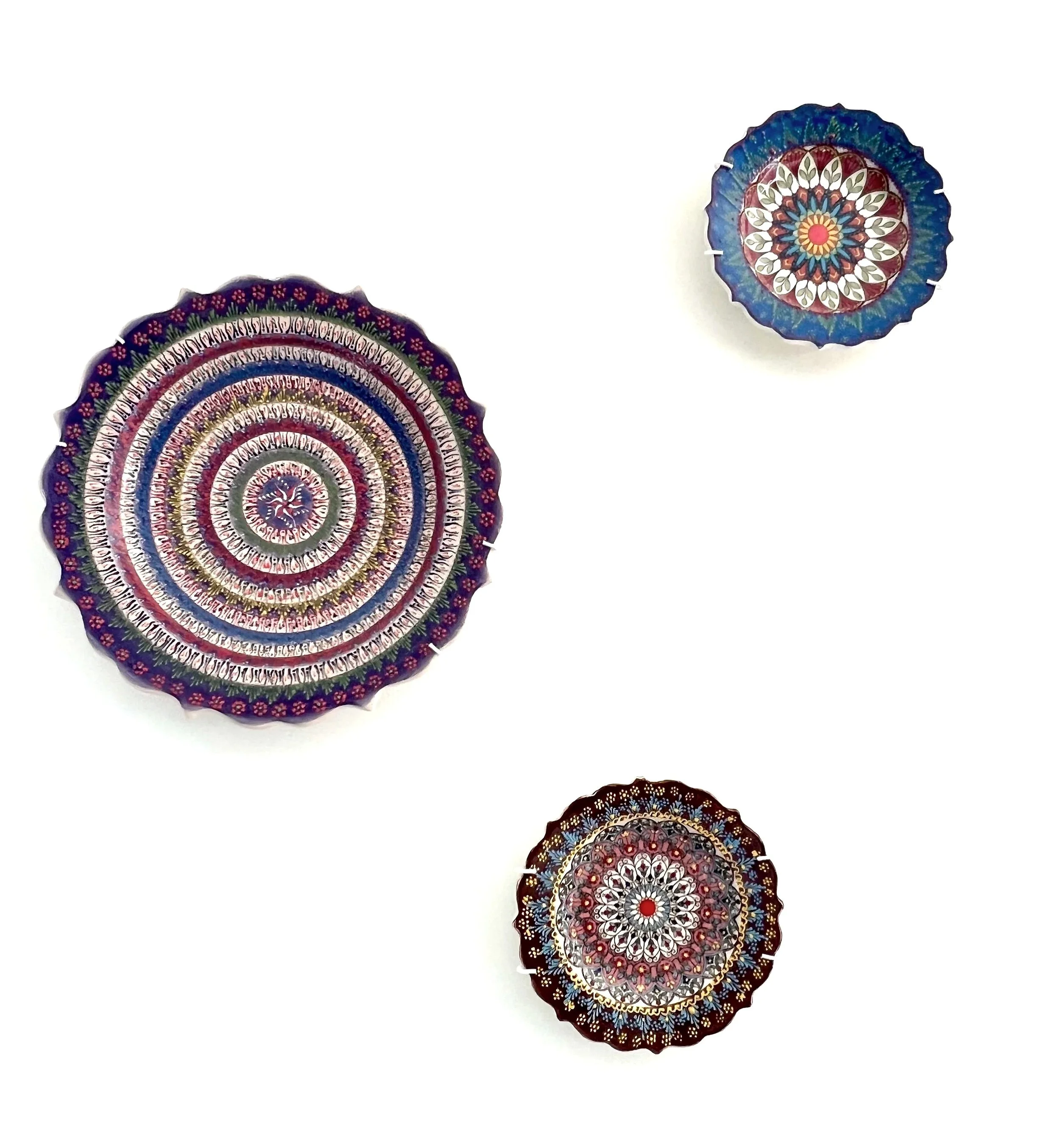 Colorful decorative plates with intricate mandala-like patterns on a white background.