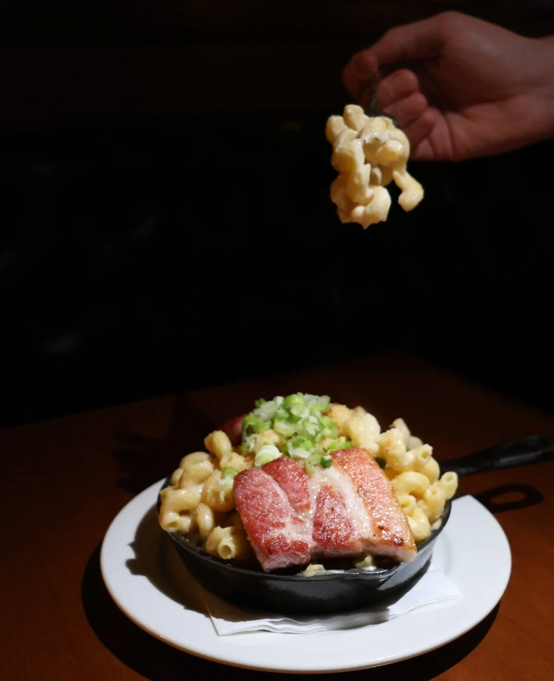 Mac and cheese in a cast iron skillet with scallions and pork belly at Tavern Law on Capitol Hill