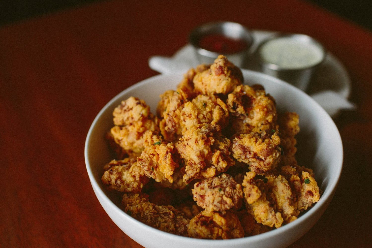 A bowl of buttermilk popcorn chicken with dipping sauces, a happy hour plate at Tavern Law on Capitol Hill