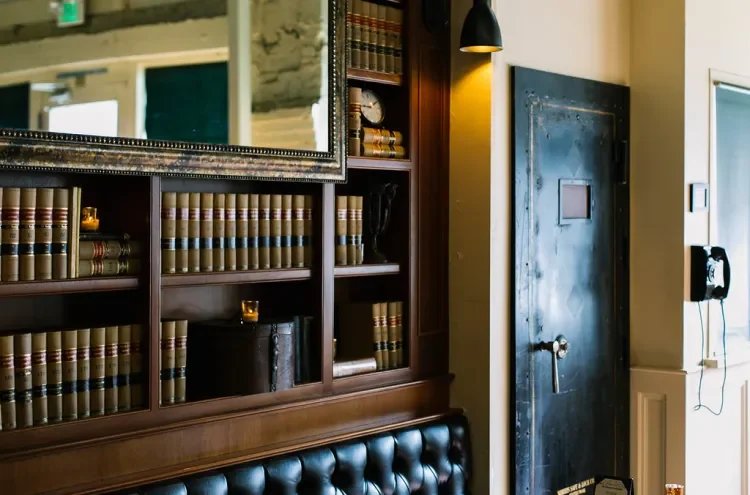 Law-book shelves beside the vault door at Tavern Law, the entrance to the Needle & Thread speakeasy.