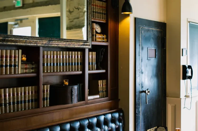 Shelves of old law books beside the vault door at Tavern Law, the entrance to the Needle & Thread speakeasy.