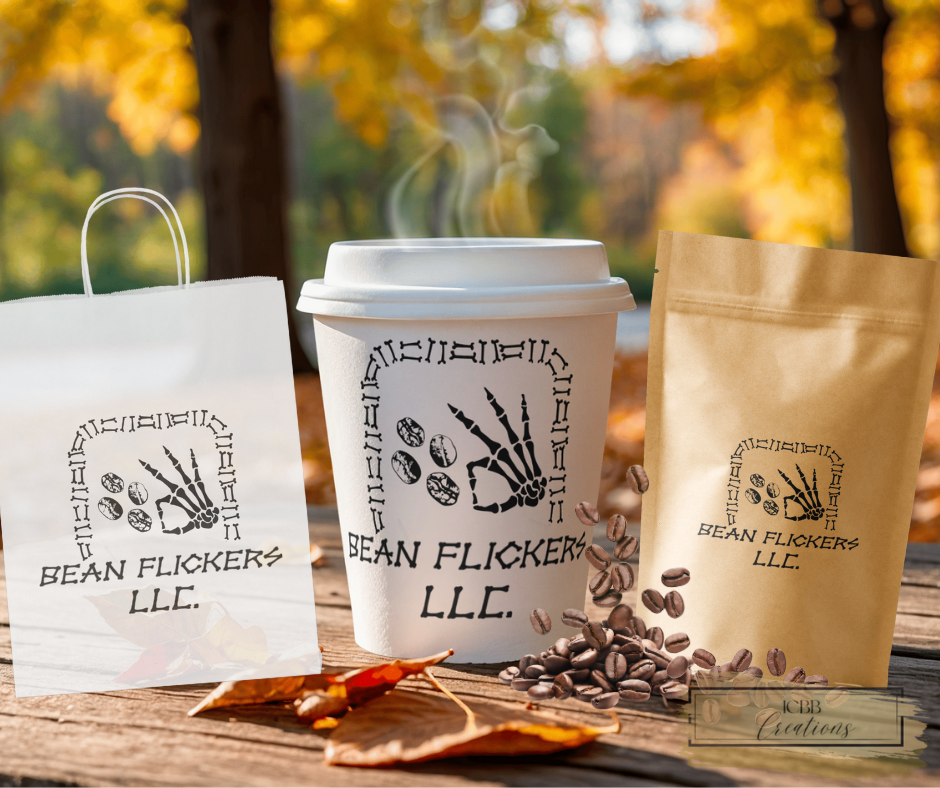 A coffee cup, a paper bag, and a paper bag with a logo that says 'Bean Flickers LLC' on a wooden table outdoors with autumn leaves and trees in the background.