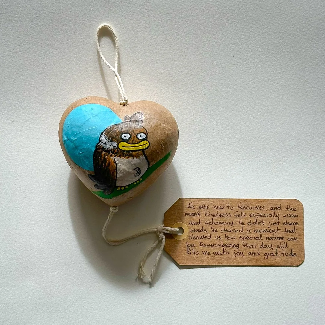 A cardboard heart shaped kindbloom decorated with a cartoon chickadee