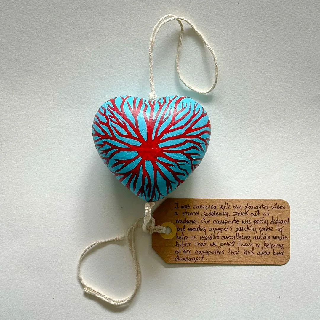 A cardboard heart shaped kindbloom decorated with a red rizome