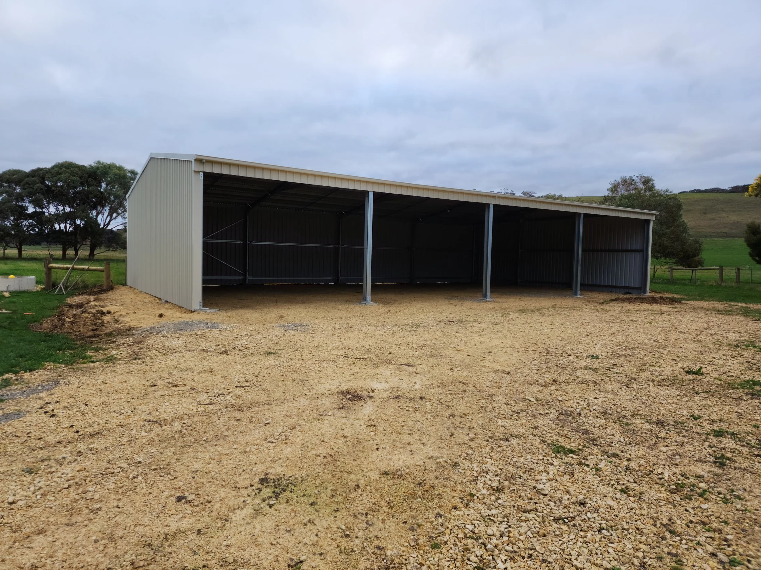 A large, metal carport storage shed with a sloped roof, built by M&C Sheds