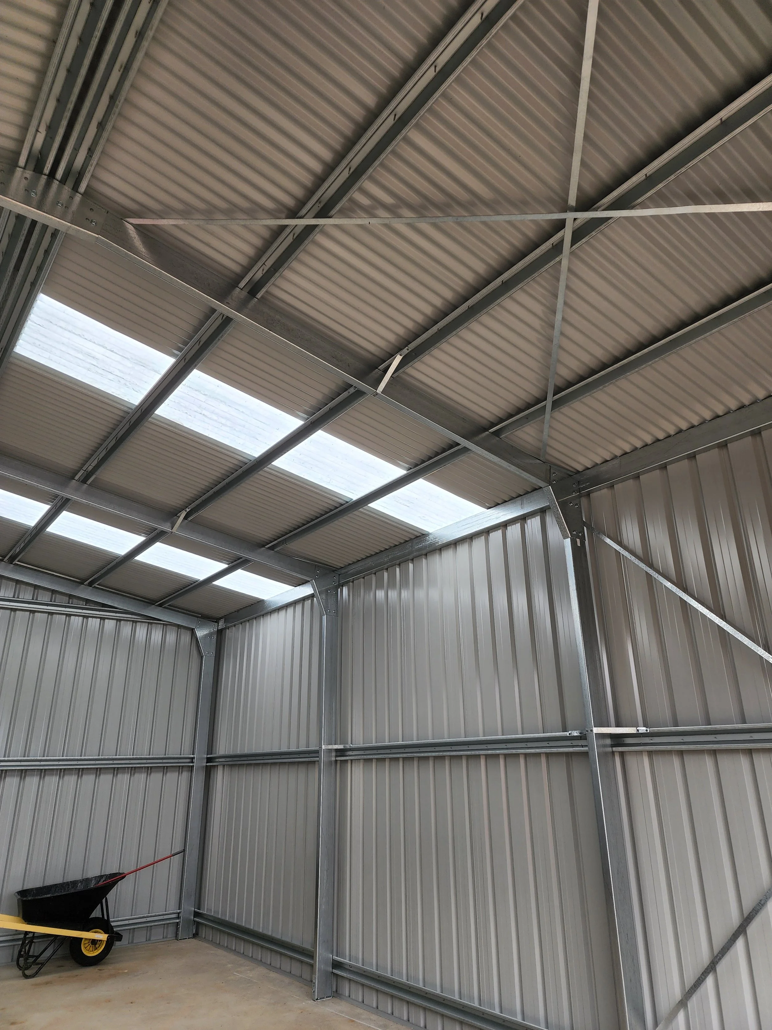 Interior of a garage storage shed with metal walls and ceiling built by M&C Sheds