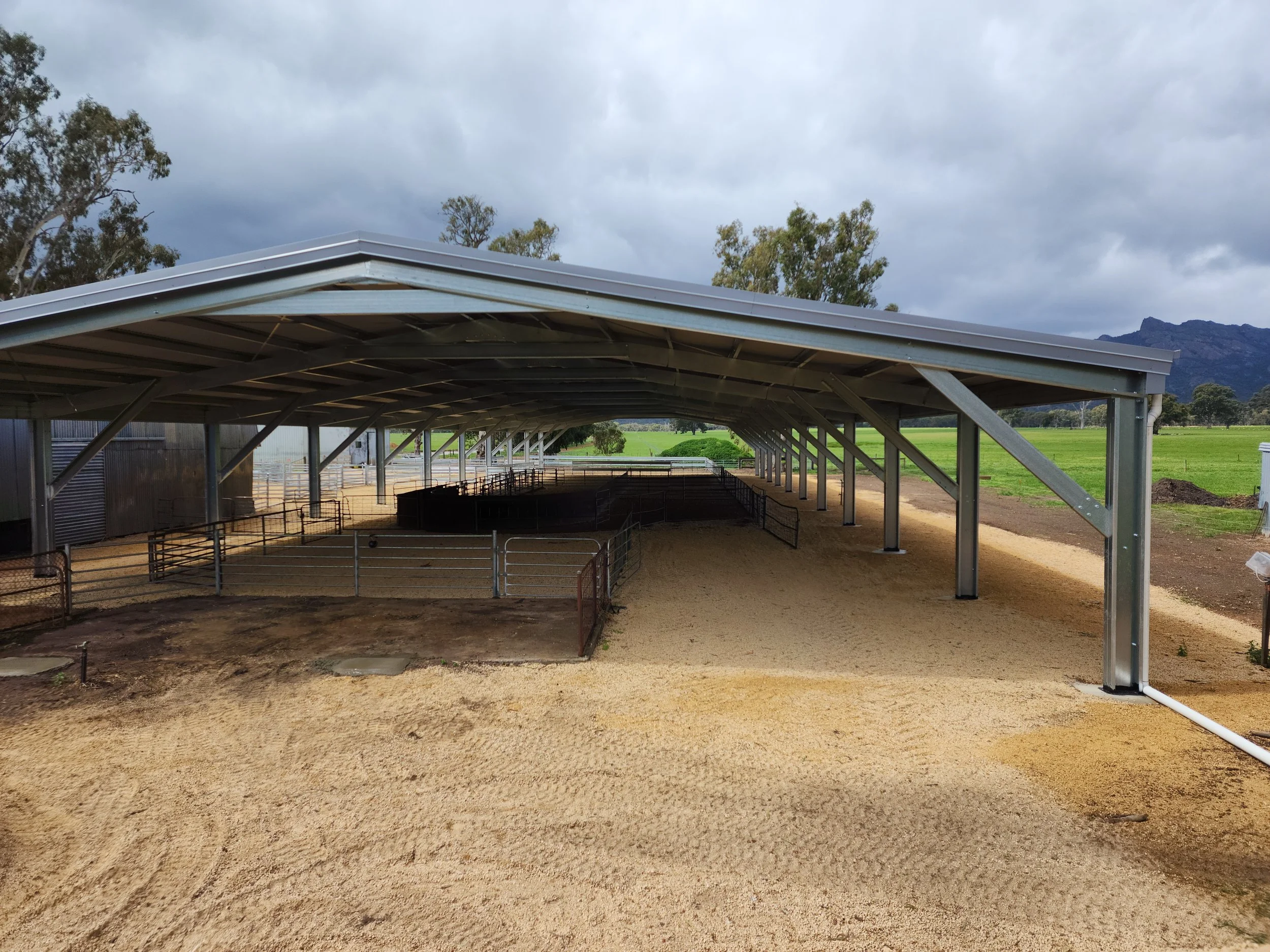 A metal structure shed under construction with a roof, built by M&C Sheds