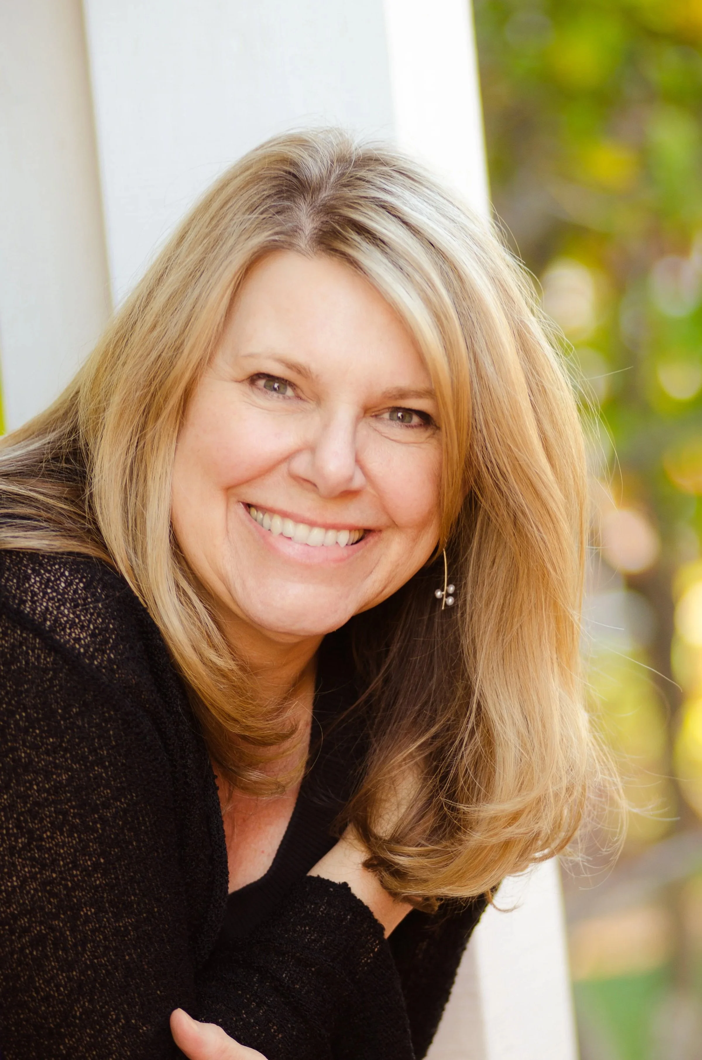head shot of woman with long hair and wearing black sweater