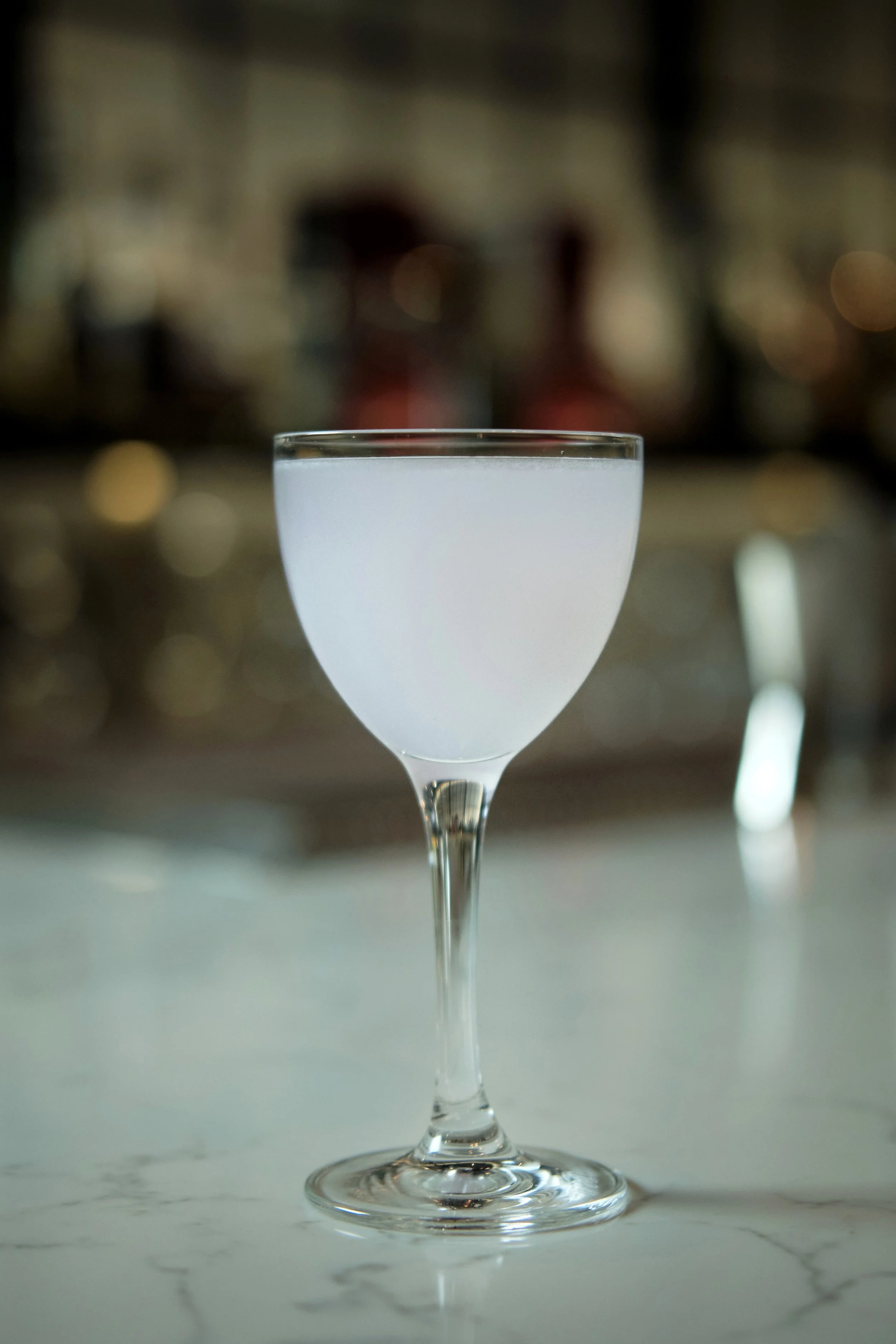 A glass of milk on a marble countertop with a blurred background of city lights.