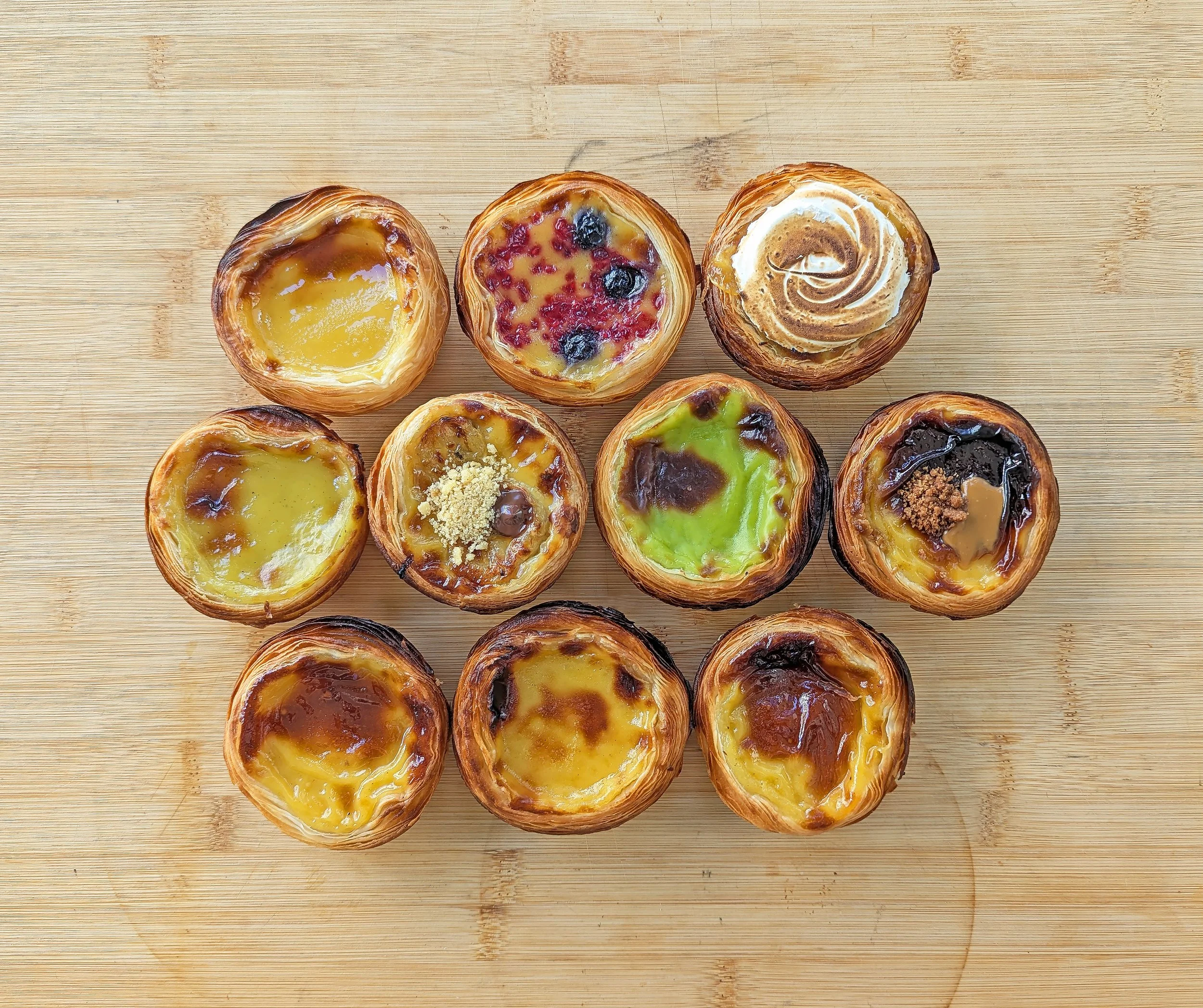 A photo of 10 portuguese tarts from above