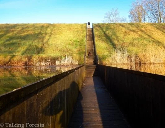 Green grass on either side of a long walkway through this moat.