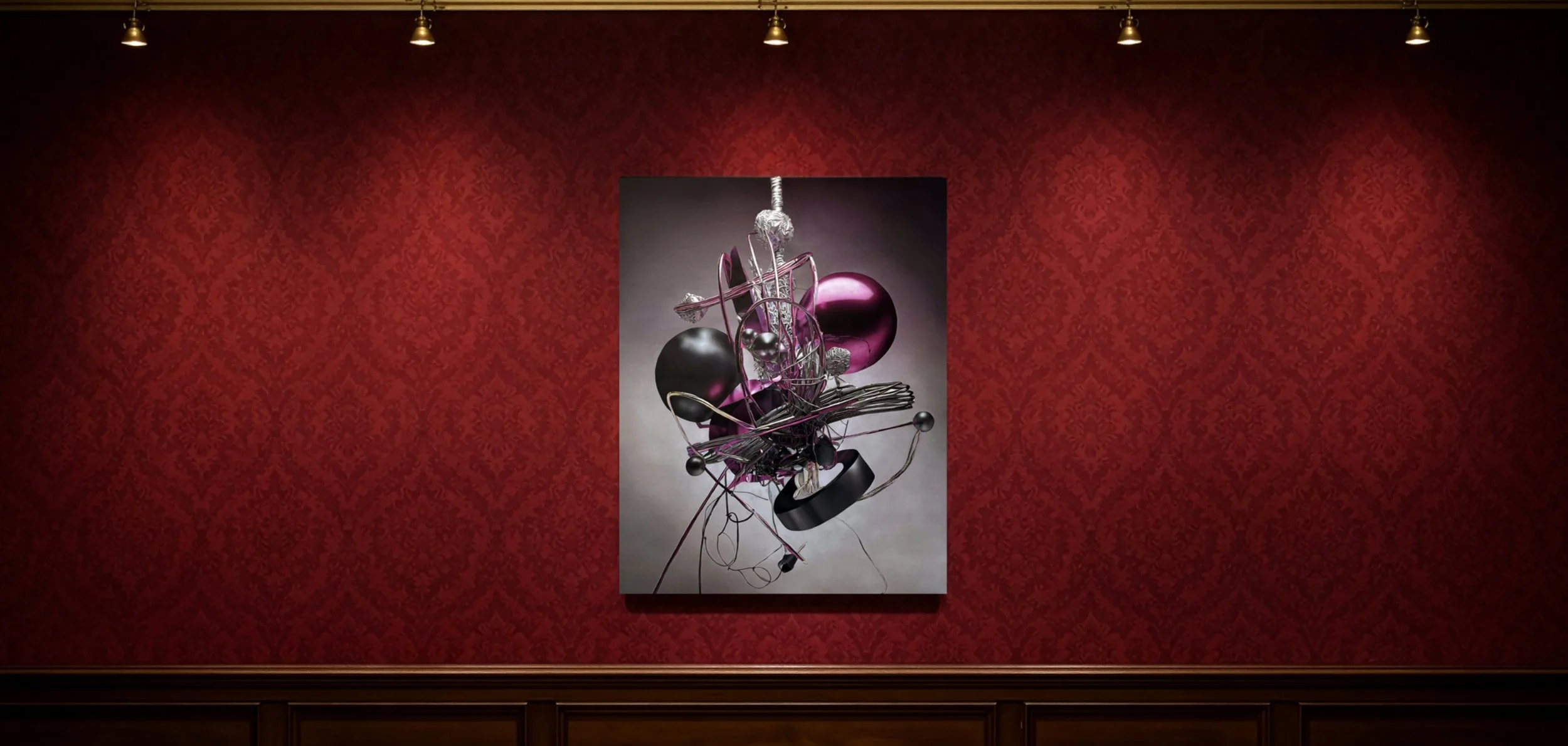 Abstract sculpture with metallic and colored spherical components, suspended and arranged against a gray background, displayed on a red patterned wall in an art gallery.