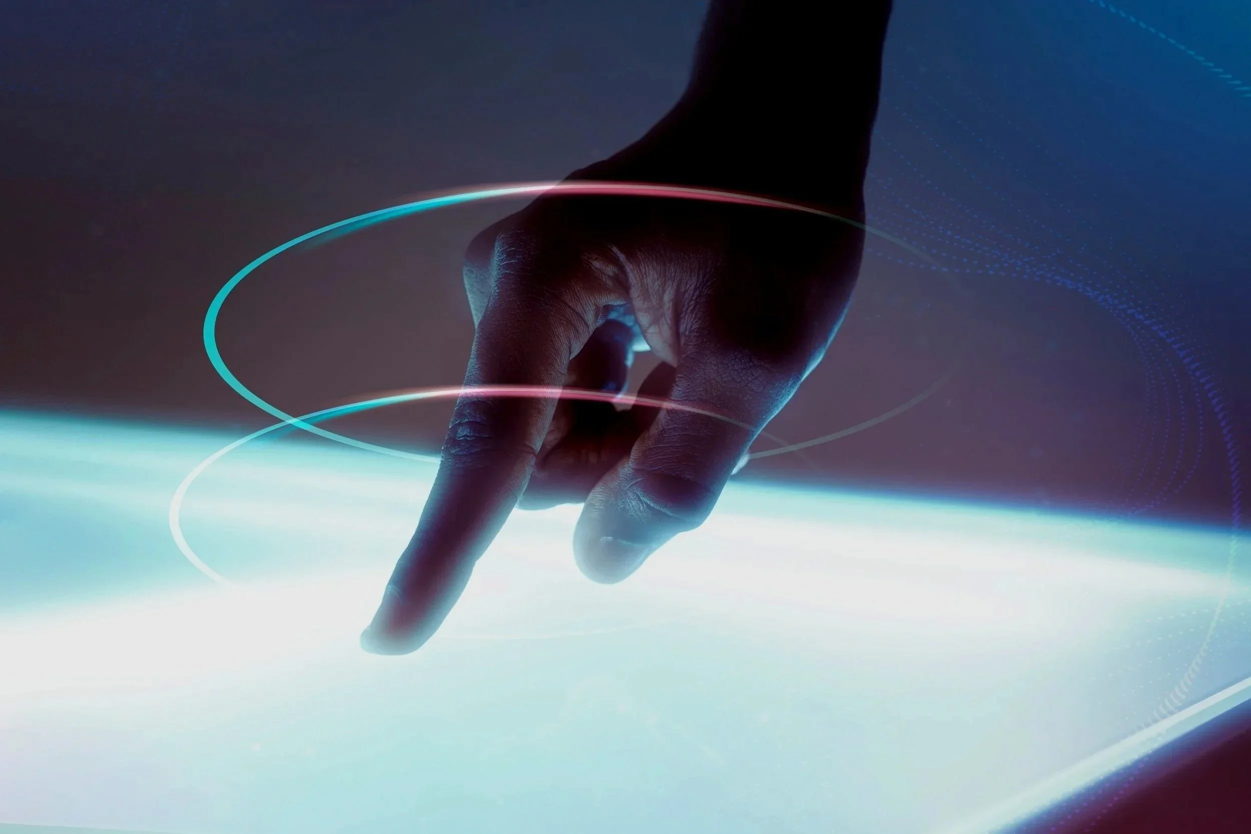 A hand pointing downward with digital light circles and lines around it, suggesting a futuristic touchscreen interface.