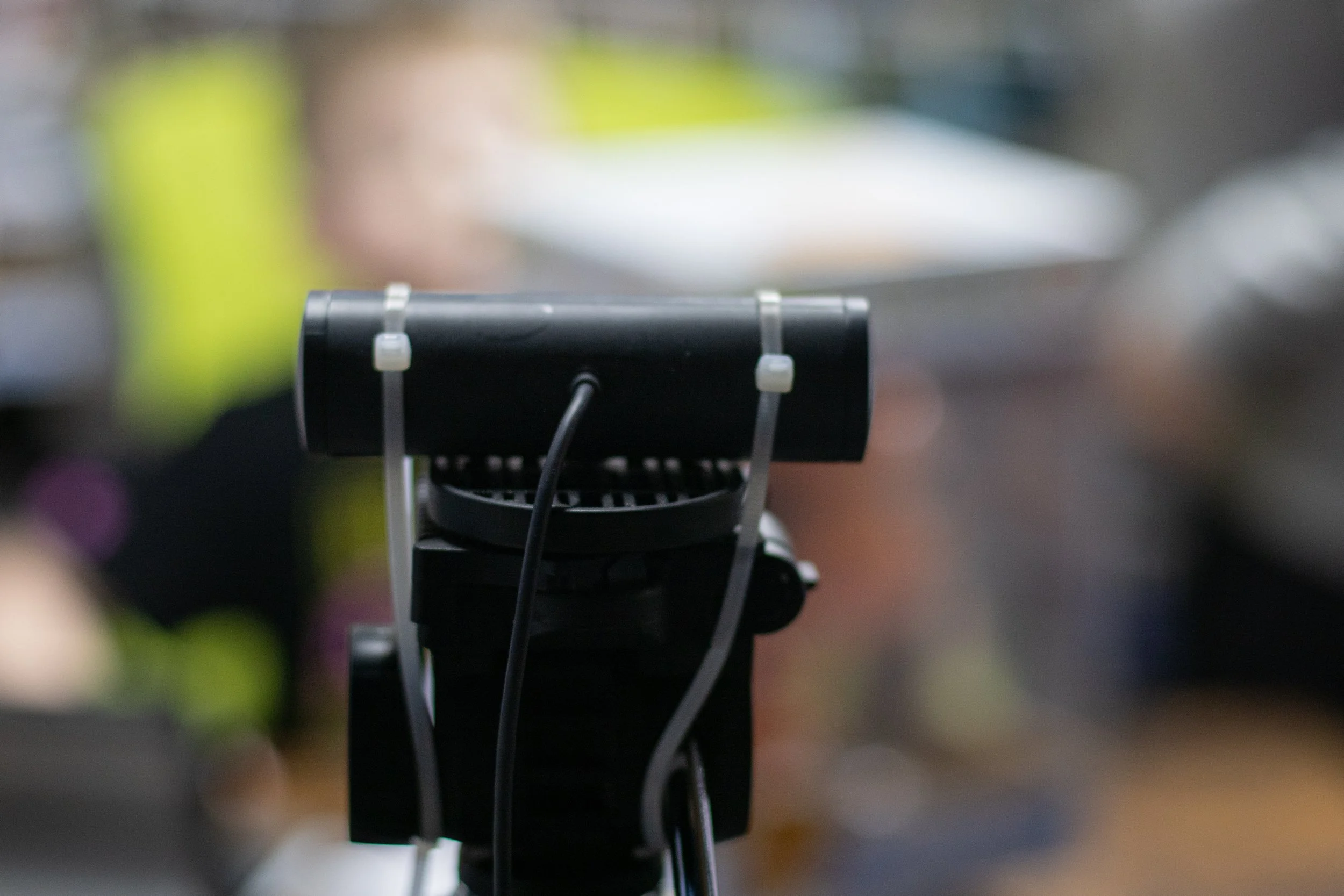 Close-up of a black microphone mounted on a stand, with a blurred background.