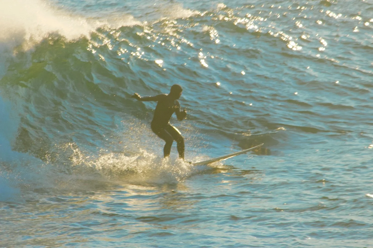 A person surfing on a wave in the ocean during daylight.