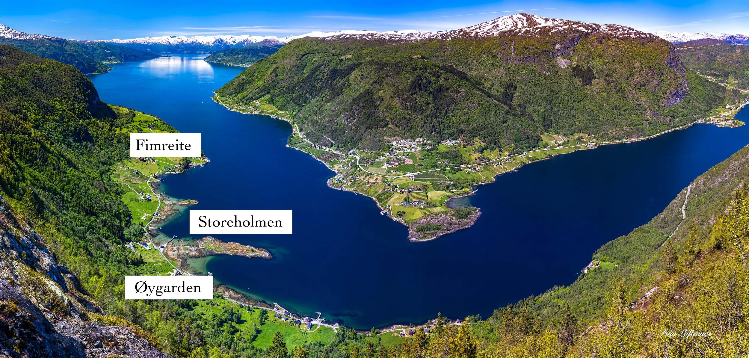 Utsikt over Sognefjorden, dronefoto, med merka områder kalla Øygarden, Storeholmen, Fimreite, og en liten tettstad på en liten ås