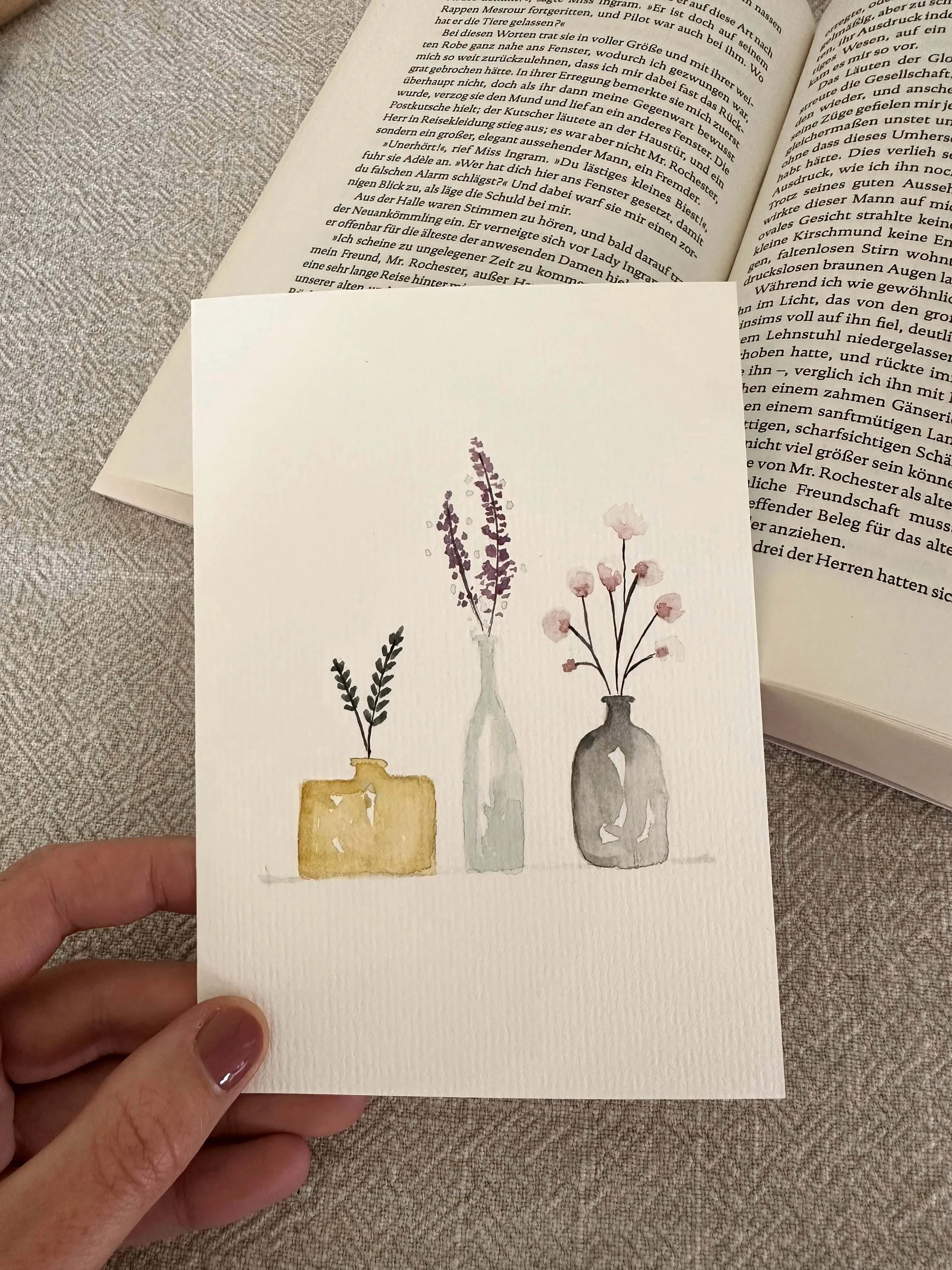 A watercolor painting of three vases with different flowers on a white textured background.