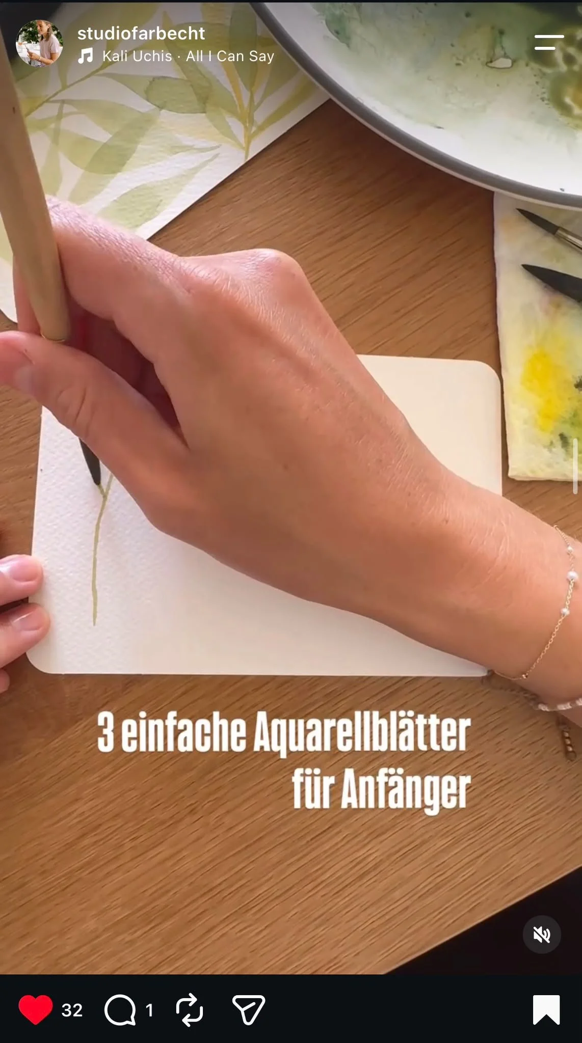 Hand zeichnet einfache Aquarallblätter auf einem weißen Aquarellpapier, im Hintergrund eine Platte mit grüner Farbe. Text im Bild: "3 einfache Aquarellblätter für Anfänger".