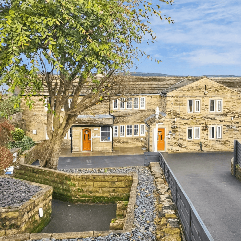 Care home building in Halifax, West Yorkshire, featuring traditional stone architecture, landscaped entrance, and a welcoming residential care setting.