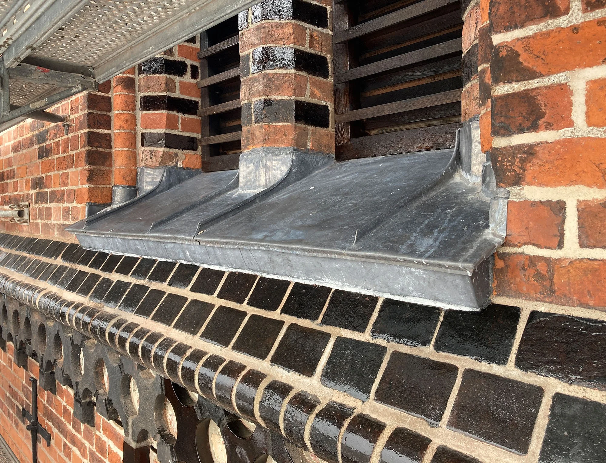 Metallsims an einer Backstein-Kirche, momentan in Reparatur mit neuem Blechanschluss.