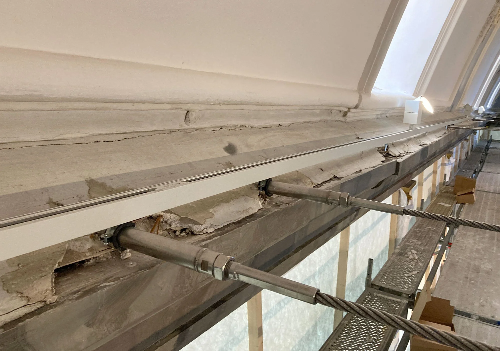 Balkon oder Außenbereich mit beschädigter und bröckelnder Mauer, Gerüst und Bauarbeiten in Arbeit