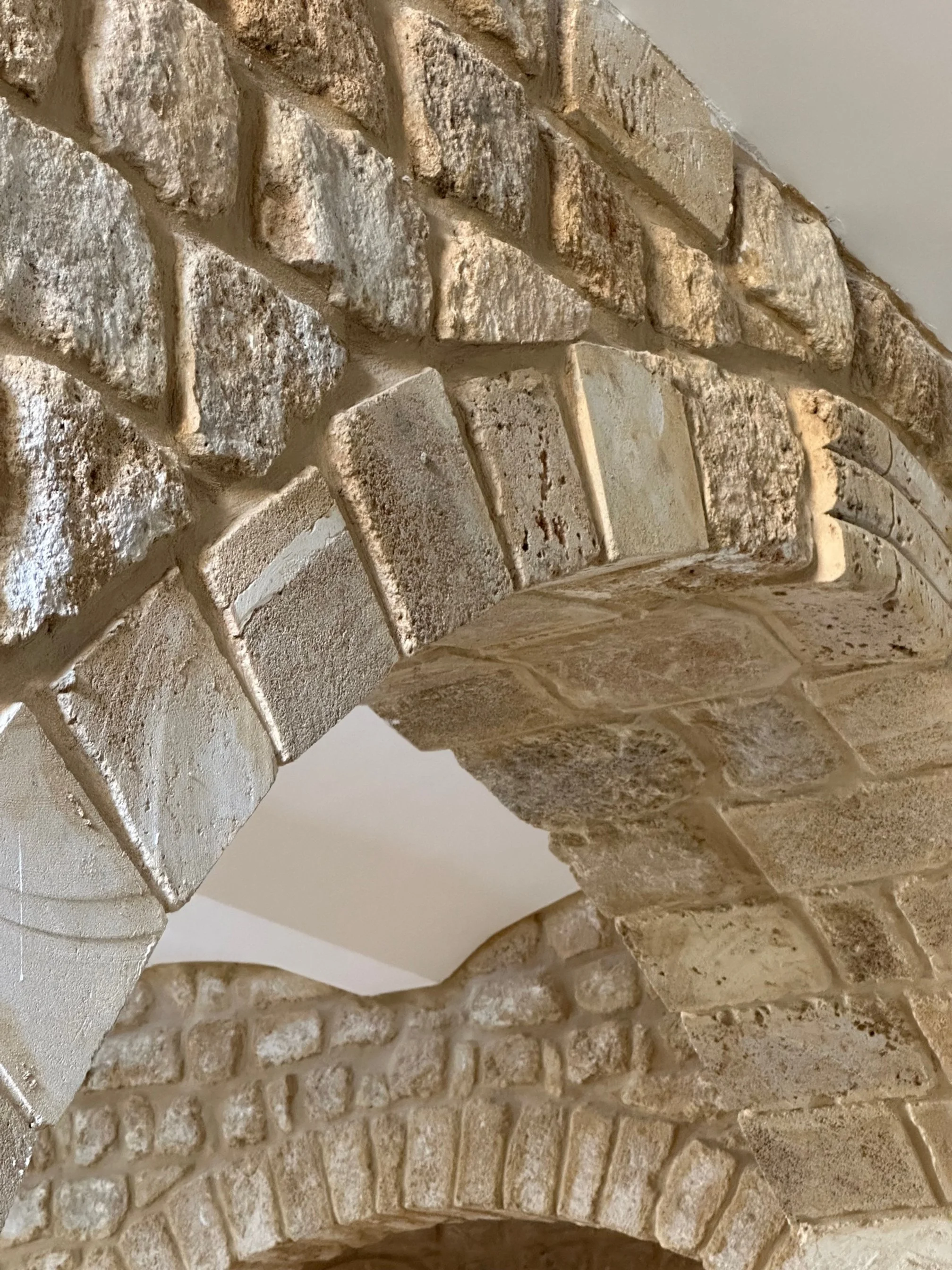 Close-up of a brick fireplace with beige and brown tones, showing brick arch details.