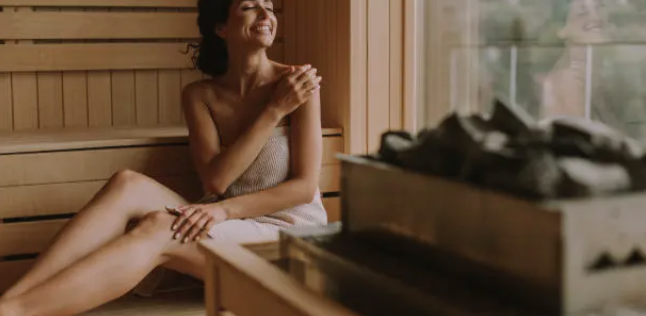 Femme détendue profitant d'une séance individuelle dans le sauna traditionnel en bois