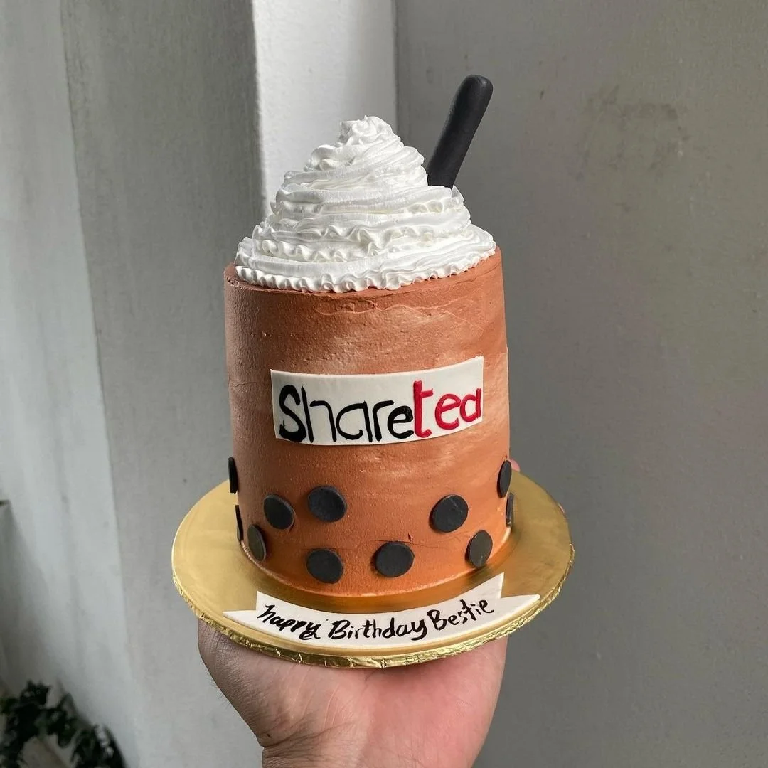 Sharetea boba tea cake with whipped cream, black boba pearls, a straw, and 'Happy Birthday Bestie' message.