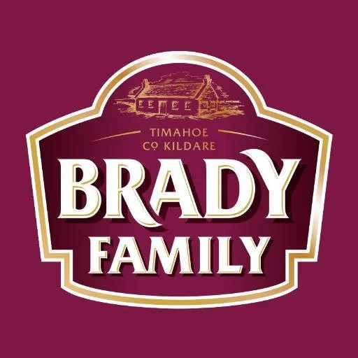 Logo for Brady Family in Timahoe, County Kildare, with a depiction of a house or building at the top on a purple background.