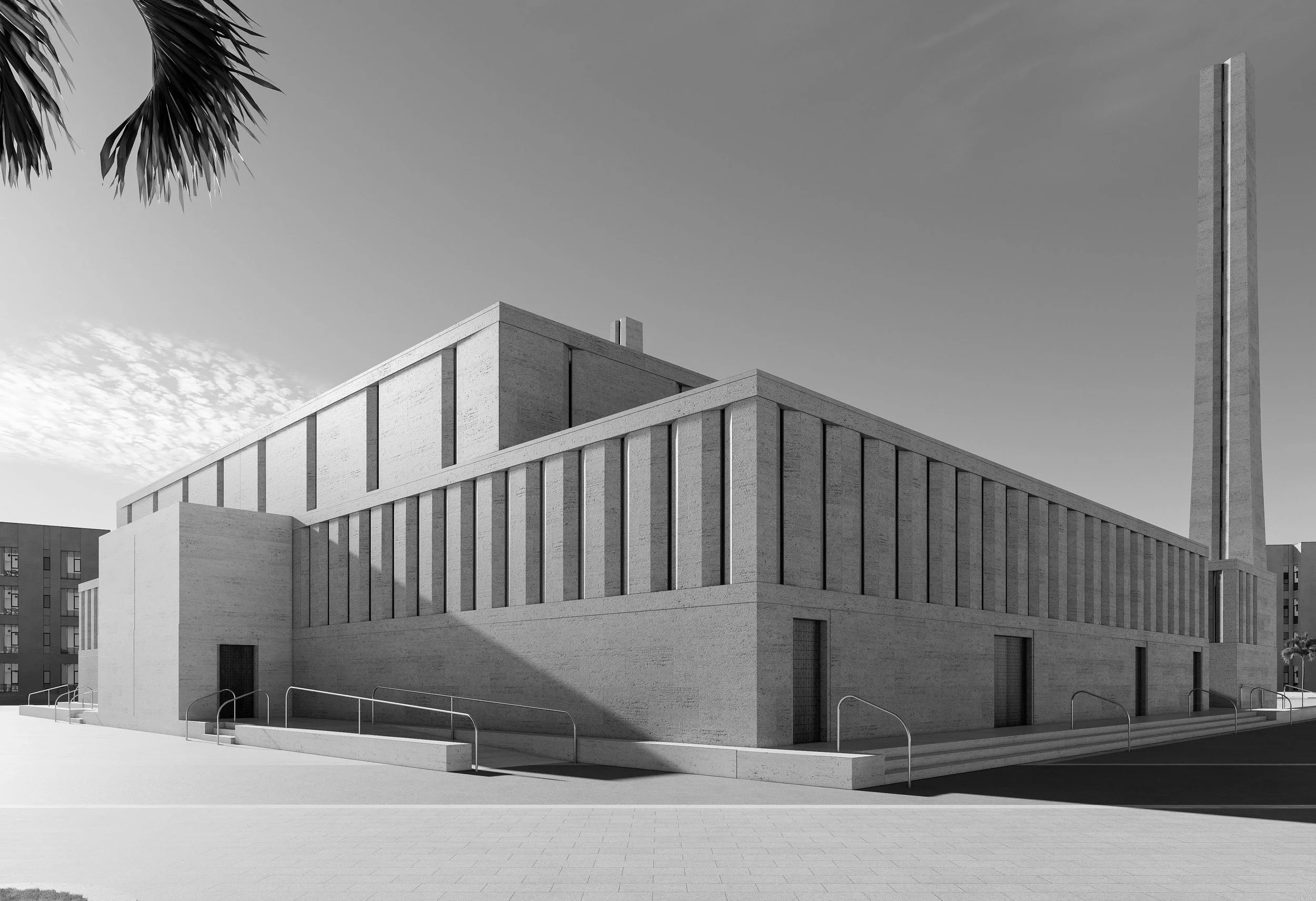 Edificio moderno de color claro con varias ventanas, y una torre alta en el fondo, en un entorno urbano, en un día soleado.