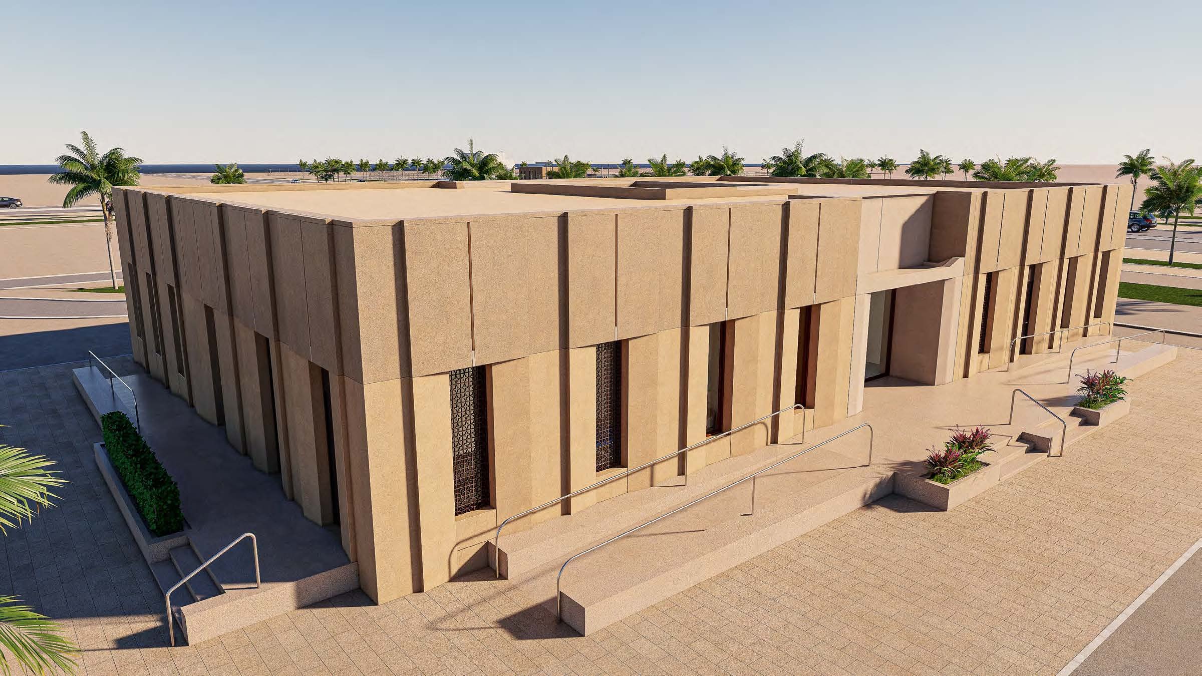 Edificio moderno de color arena con ventanas estrechas y rampas de acceso en la entrada, rodeado de plantas y palmeras.