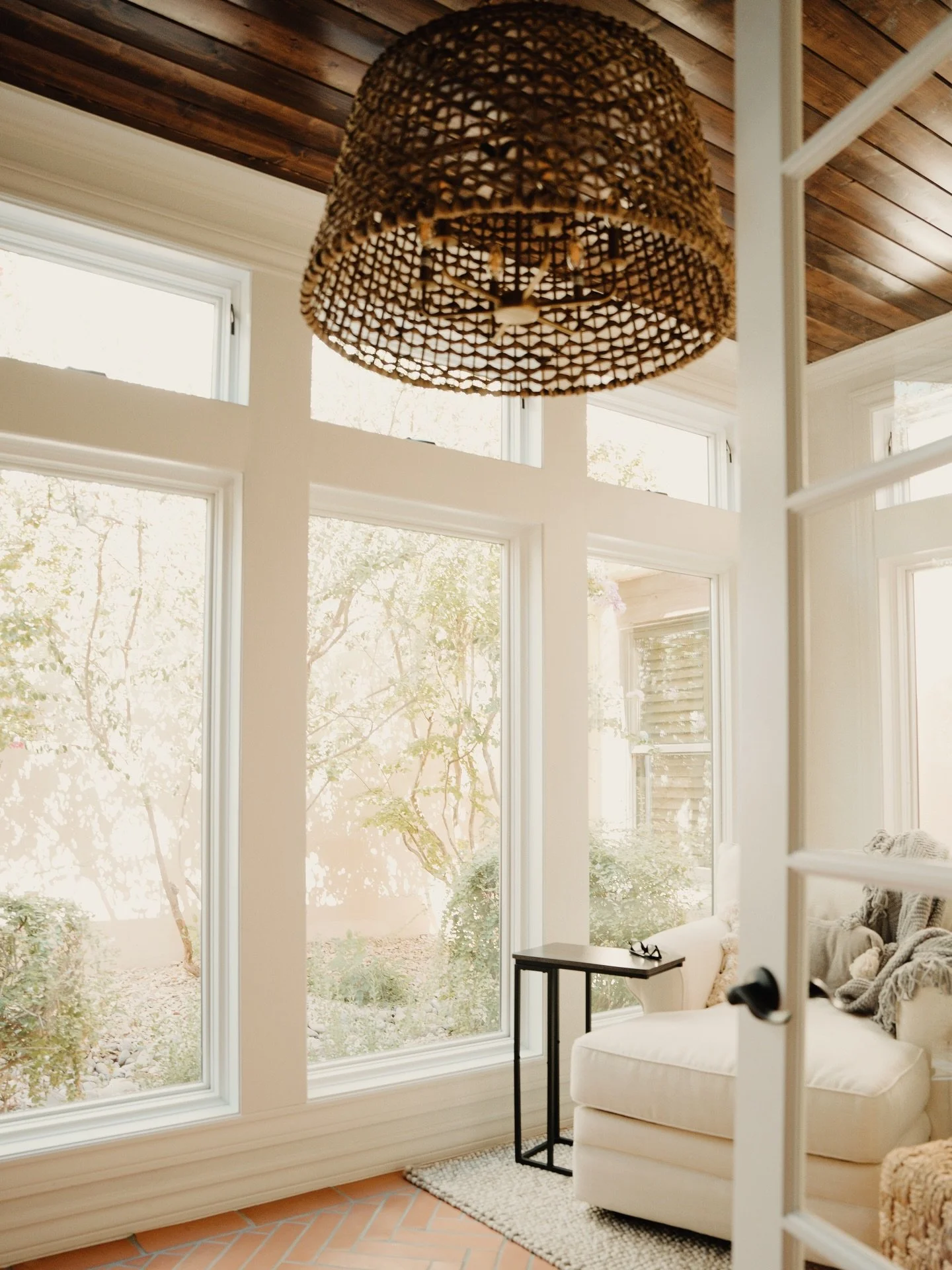 We love designing cozy and comfortable spaces, and this little spot was no exception! With our signature elegance and southwestern flare, we brought this sunroom addition to life with terracotta tile, a wood plank ceiling, a textured chandelier, and 