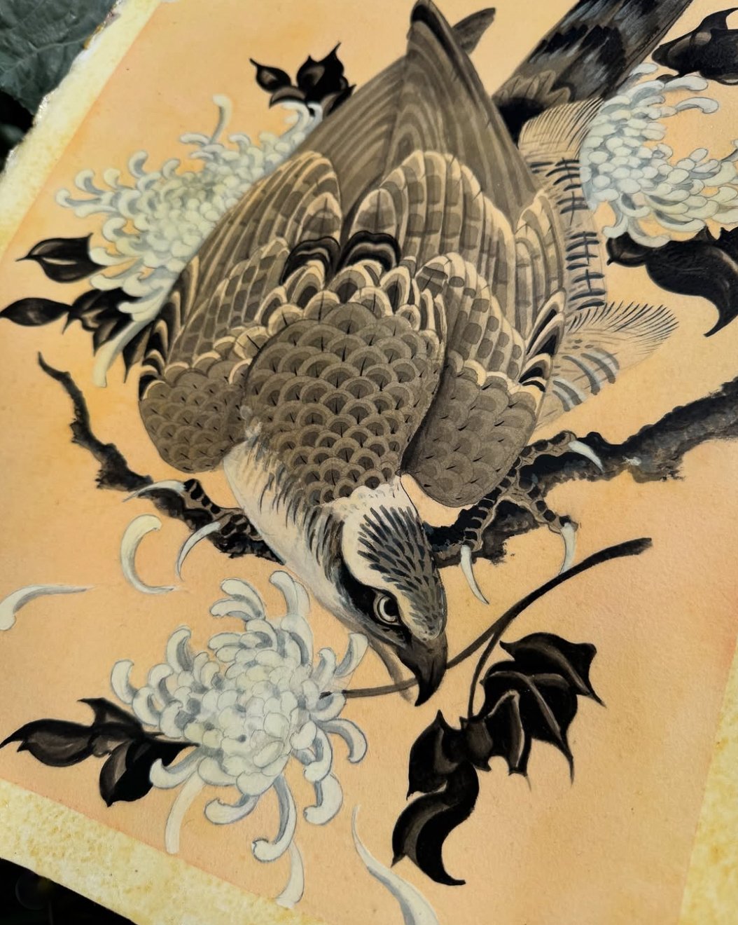 A traditional Asian ink painting of a bird, possibly a hawk, perched on a branch with flowers and leaves, rendered in black, white, and gray tones.