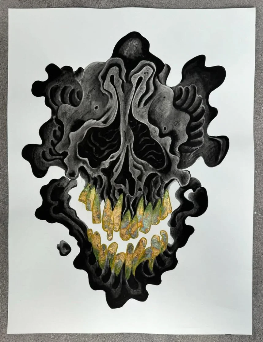 An abstract black and gray illustration of a skull with swirling and dripping patterns, featuring gold and glitter accents on the teeth, on a white background.