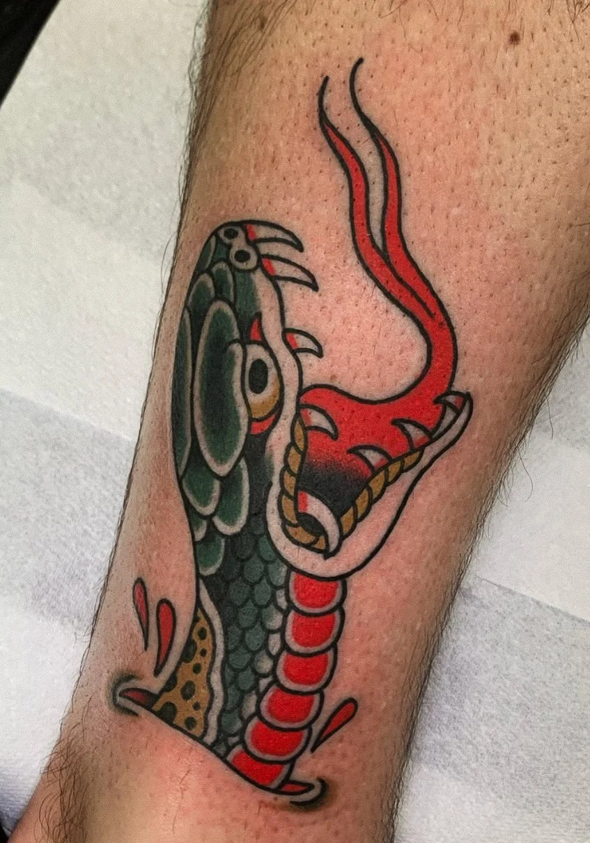 Tattoo of a snake and a dragon, with the snake depicted in red and the dragon in green and black.