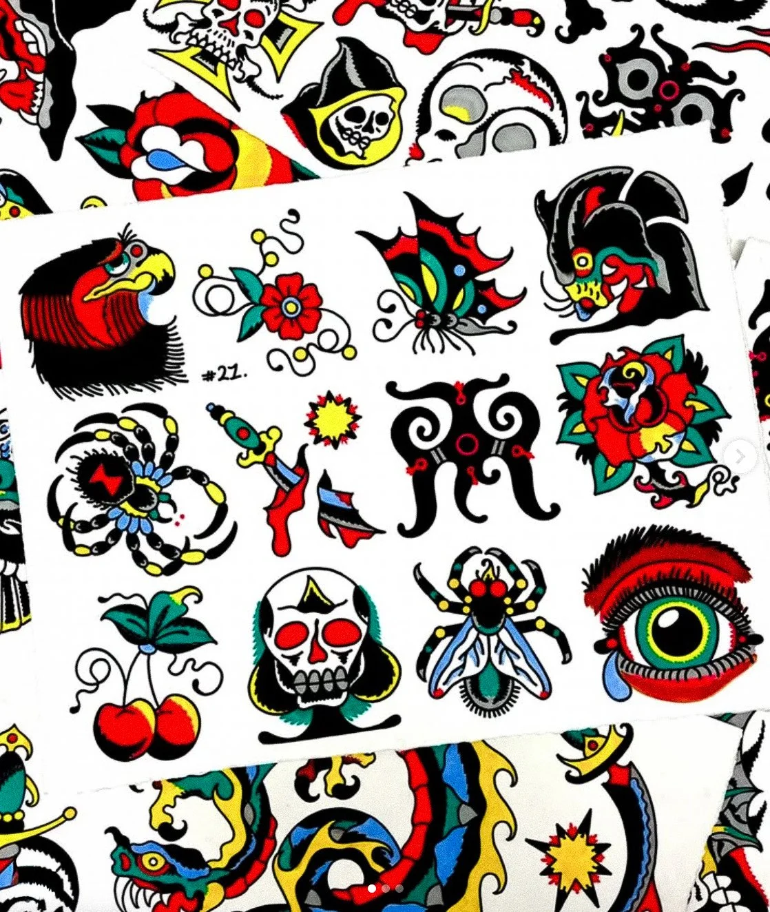 A collection of traditional American tattoo flash designs featuring skulls, a dragon, spiders, bats, cherries, and a colorful eye, all in a vintage tattoo style with bold black outlines and vibrant colors.