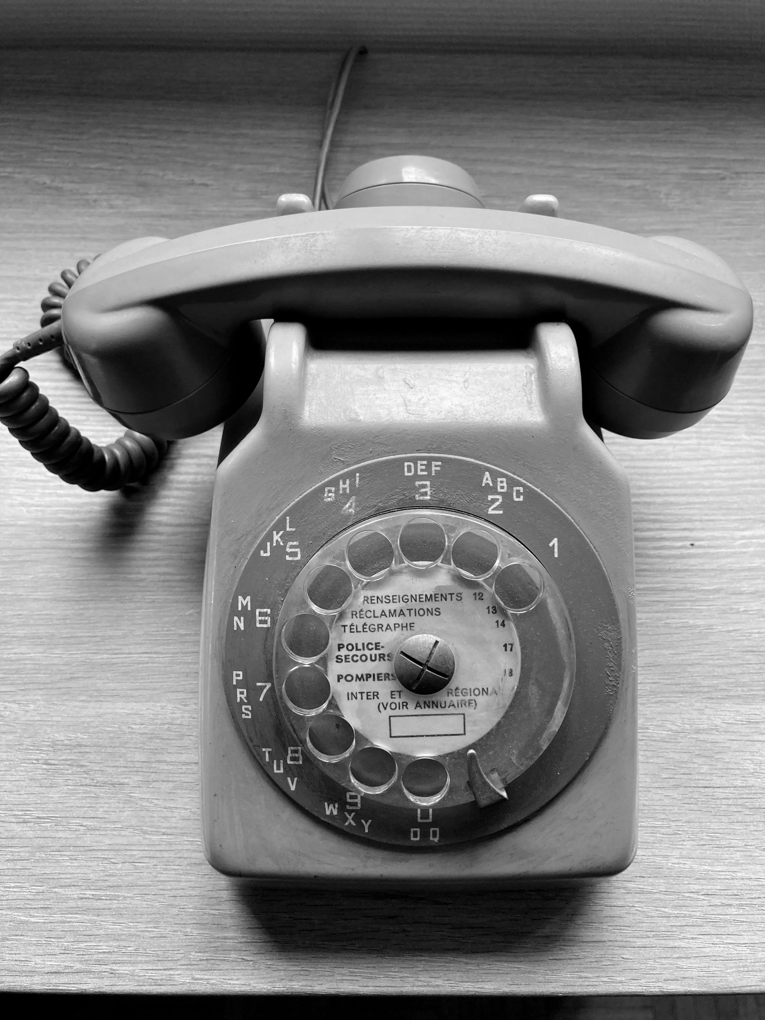 Téléphone vintage en noir et blanc avec cadran rotatif.