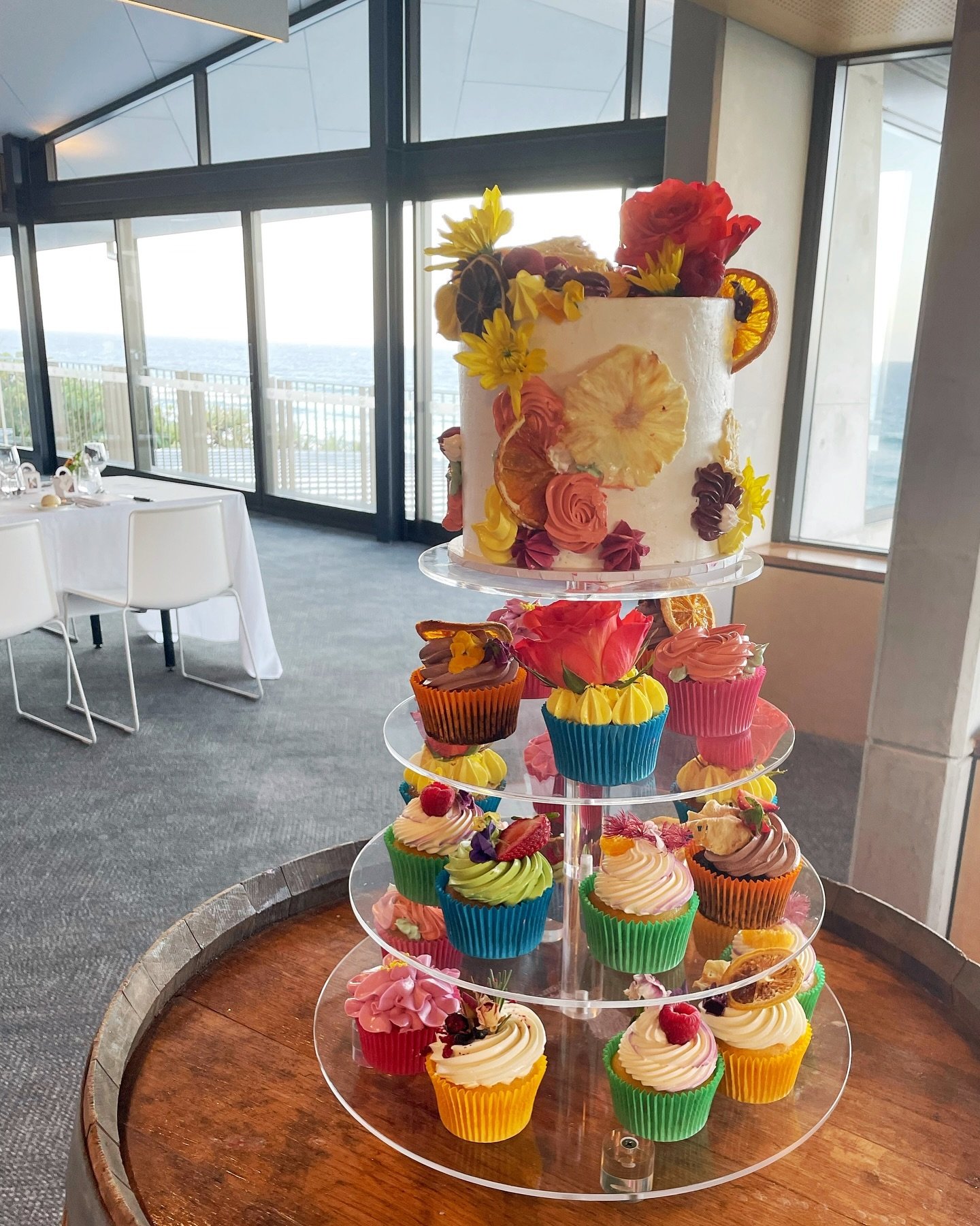 Full setup with the bright and floral wedding cupcakes and cake. 

I&rsquo;m in love with the non traditional style - classic white cakes are great, but bringing your personality into them makes them that much more special ✨