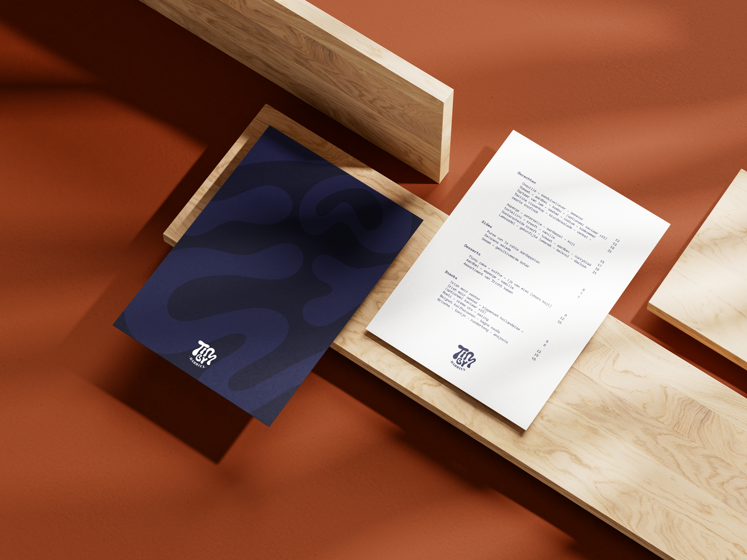 A restaurant menu and a dark blue folder with abstract patterns on a wooden table against a brown background.