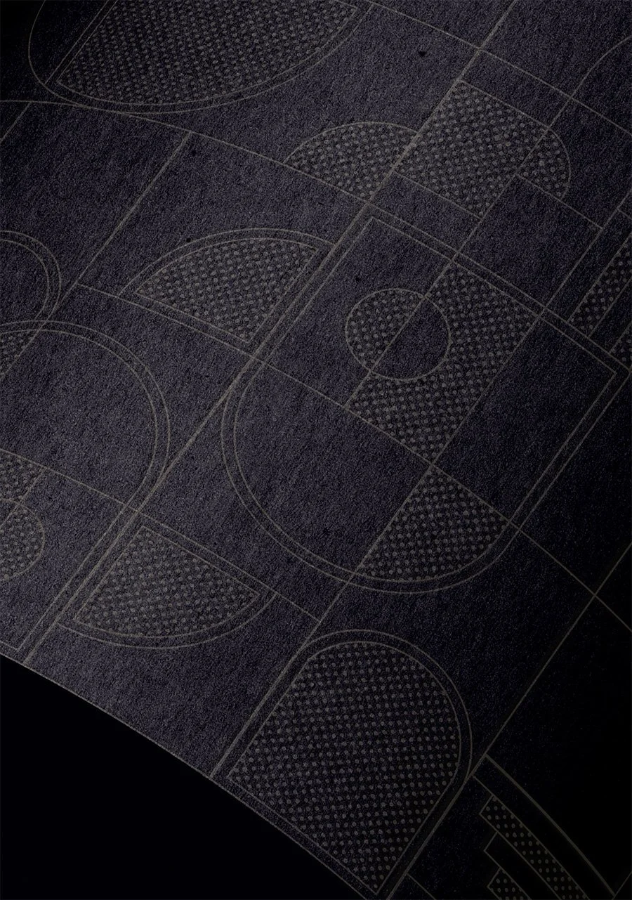 Close-up of a dark floor with white line markings of multiple basketball courts.