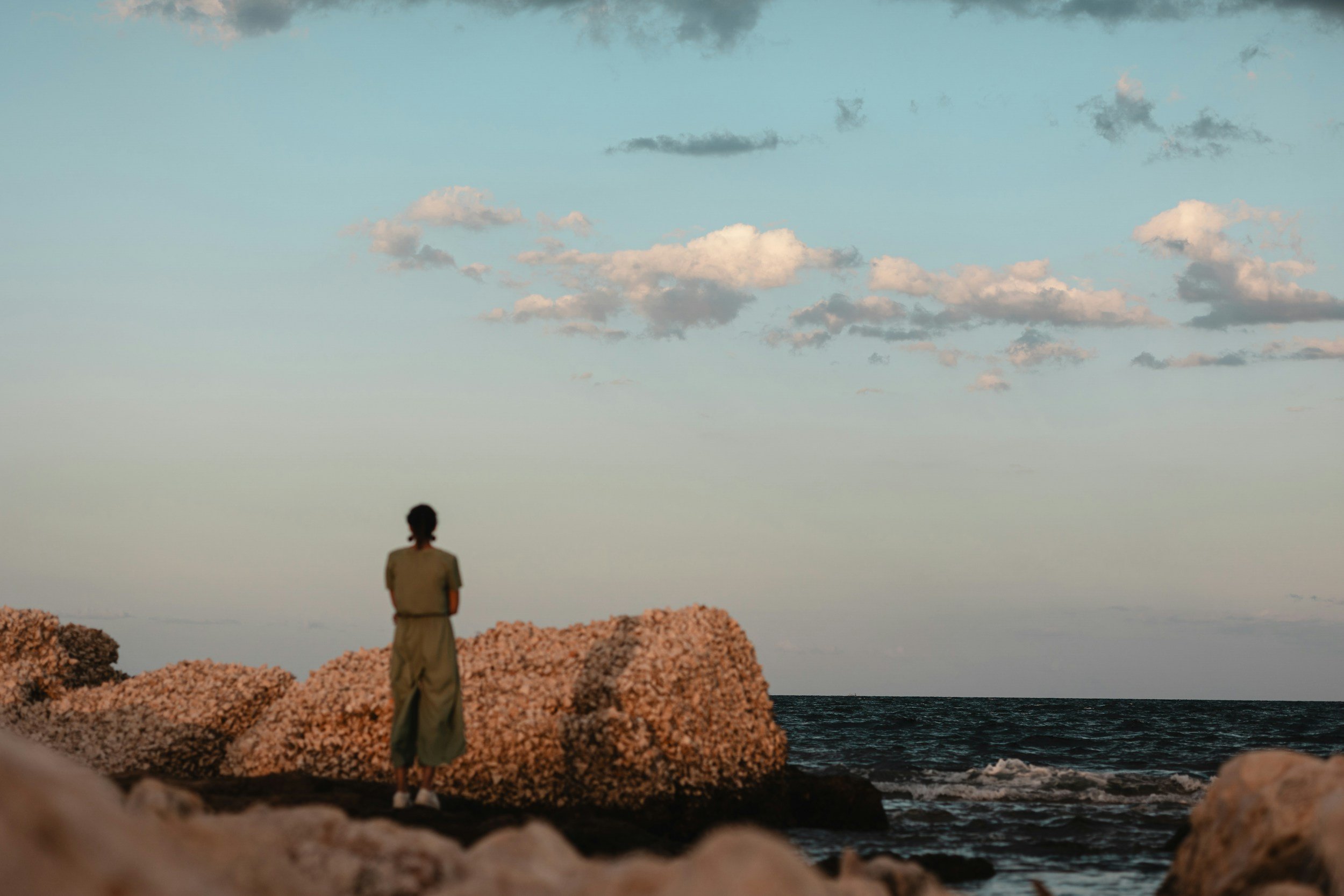 Woman at the ocean representing peace and grounding