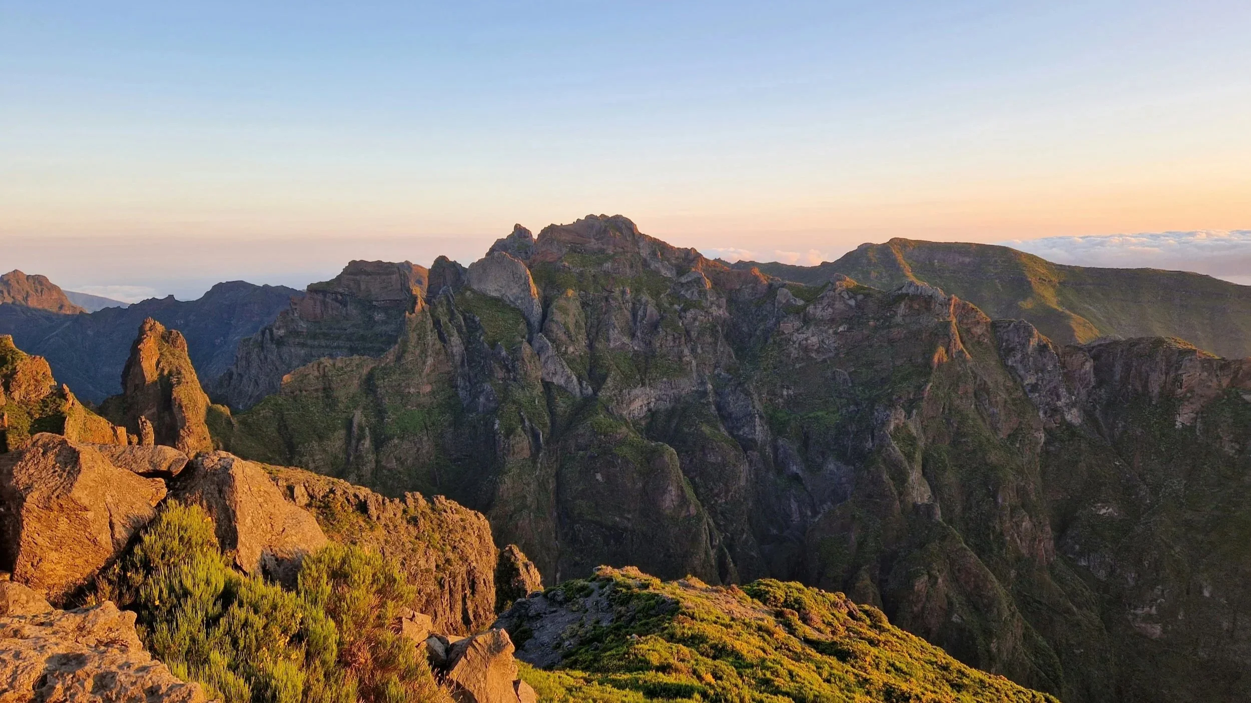 Berglandschaft bei Sonnenuntergang mit Felsen und grünen Vegetation