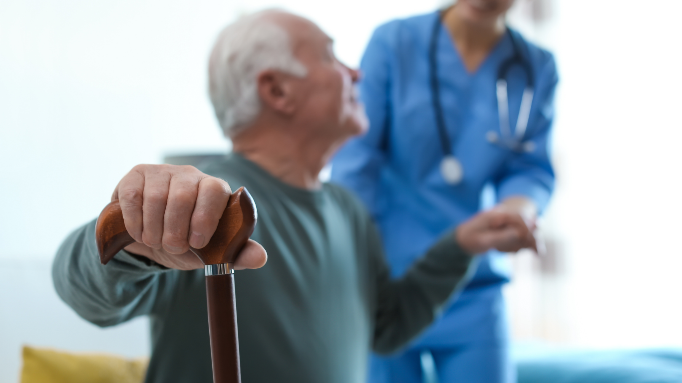 Caregiver assisting man with a cane