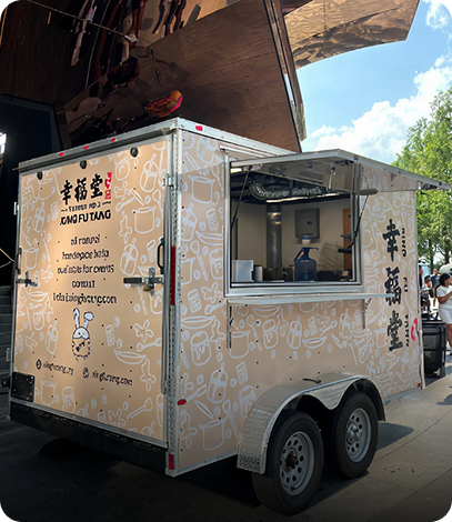 Food truck with beige exterior decorated with white line drawings of kitchen utensils and ingredients