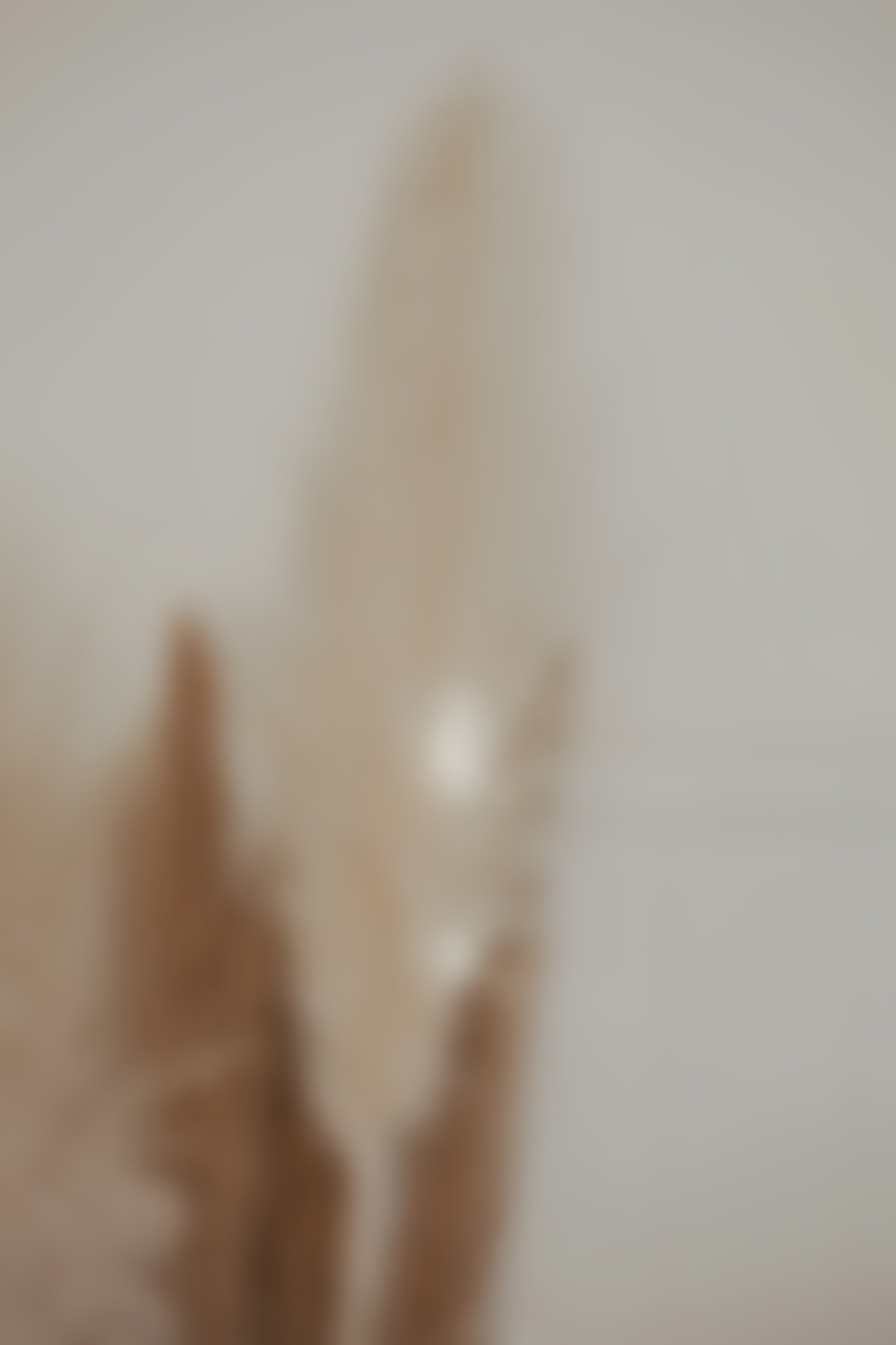 A blurry photo of a hand with two fingers raised, against a light background.